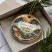 A decorative ornament with a scenic landscape of Sunset Bay State Park, Oregon, featuring a sunset over the water and pine trees.