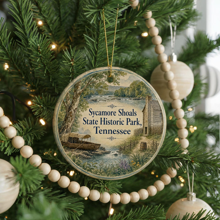 A round ornament hanging on a Christmas tree, featuring a scenic image of Sycamore Shoals State Historic Park in Tennessee.