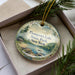 A decorative ornament with a scenic lake and forest landscape, featuring the text "Thomson's Lake State Park, New York".