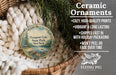 Ceramic ornaments, including a round ornament with a scenic lake and pine trees, are displayed in a woven basket.