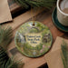 A decorative ornament featuring a scenic image of Tinkers Creek State Park, Ohio, surrounded by pine branches and a cup of coffee on a wooden surface.