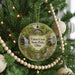 A round ornament hanging on a Christmas tree, featuring a scenic image of Tinkers Creek State Park, Ohio.