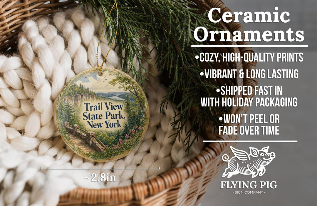 Ceramic ornaments, specifically a "Trail View State Park, New York" ornament, are displayed in a woven basket. The ornament features a scenic landscape with a bridge and trees. The text highlights the ornament's features, such as being cozy, high-quality, vibrant, and long-lasting, and mentions that it is shipped fast and comes with holiday packaging. The image also includes a scale for the ornament, indicating it is 2.8 inches in diameter.