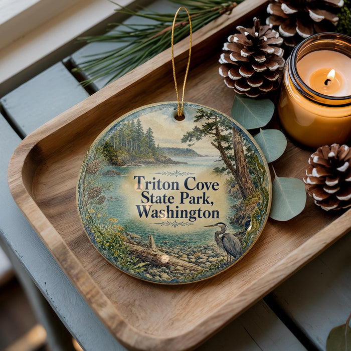 A wooden tray with a decorative ornament featuring a scenic landscape of Triton Cove State Park, Washington, surrounded by pine cones and a lit candle.
