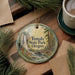 A decorative ornament featuring a scenic image of Tumalo State Park, Oregon, with pine branches and a cup of coffee nearby.
