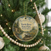 A round ornament hanging on a Christmas tree, featuring a scenic landscape with a turtle in the foreground and the text "Turtle River State Park, North Dakota".