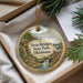 A decorative ornament with a scenic landscape of Twin Bridges State Park, Oklahoma, featuring a house, a bridge, and a bird.