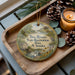 A decorative ornament with a scenic image of a river and a house, along with the text "Two Rivers State Recreation Area, Nebraska" is displayed on a wooden tray.