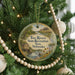 A Christmas tree decorated with ornaments, including a circular ornament with a scenic image of the Two Rivers State Recreation Area in Nebraska.