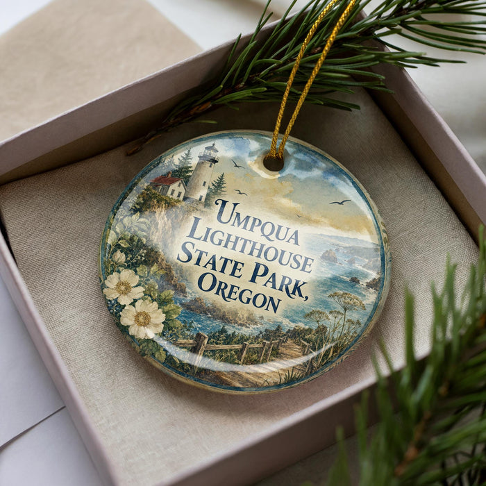A decorative ornament in a box, featuring a lighthouse and a scenic landscape.