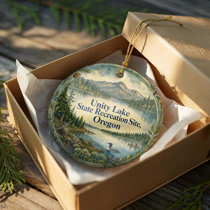A decorative ornament in a wooden box, featuring a scenic landscape with mountains, trees, and a lake.