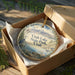 A decorative ornament in a wooden box, featuring a scenic landscape with mountains, water, and a sailboat, along with the text "Utah Lake State Park, Utah".