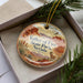 A decorative ornament in a box, featuring a scenic illustration of the Valley of Fire State Park in Nevada.