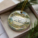 A decorative ornament with a scenic landscape of Victoria Springs State Recreation Area in Nebraska, featuring a house and greenery.