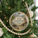 A round ornament hanging on a Christmas tree, featuring a scenic image of a historic park in Nevada.