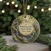 A round ornament with a scenic landscape featuring a waterfall and greenery, hanging from a string.