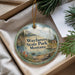 A round ornament with a scenic landscape of Wayfarers State Park, Montana, featuring mountains, pine trees, and a lake.