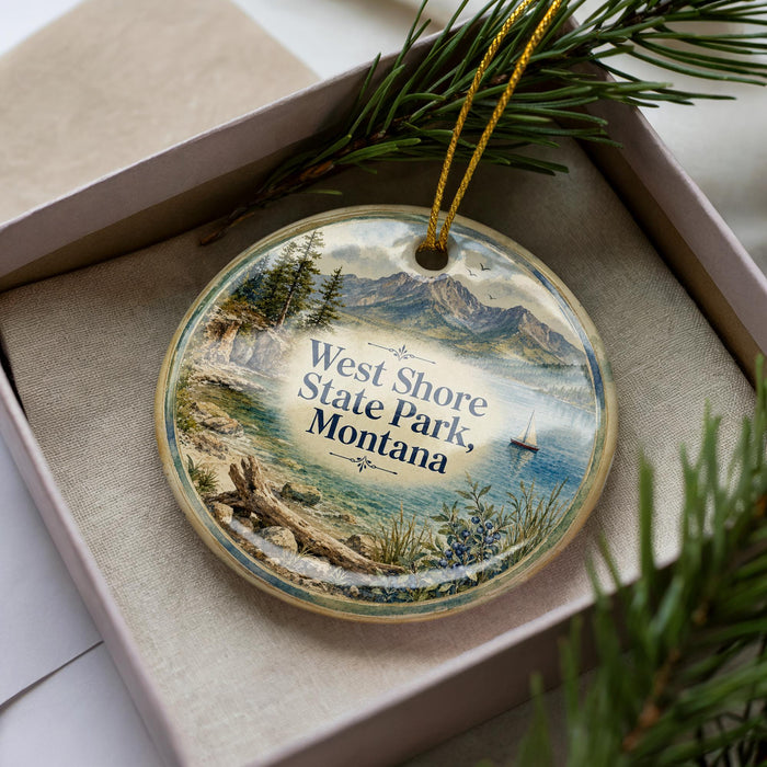 A decorative ornament with a scenic landscape of West Shore State Park, Montana, featuring a lake, mountains, and pine trees.