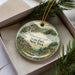A decorative ornament with a scenic landscape of Whstone Gulf State Park, New York, featuring a cabin, trees, and a waterfall.