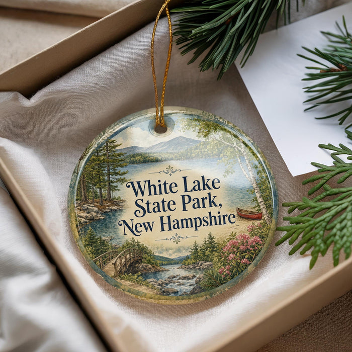 A decorative ornament with a scenic landscape of White Lake State Park, New Hampshire, featuring a bridge, pine trees, and a river.