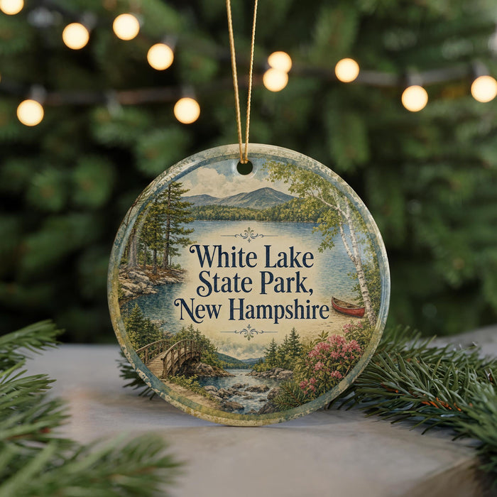 A decorative ornament featuring a scenic landscape of White Lake State Park, New Hampshire, with a bridge and trees in the background.