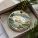 A decorative ornament with a scenic image of Whitefish Lake State Park, Montana, featuring a lake, mountains, and a boat.