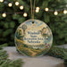 A round ornament with a scenic landscape featuring a windmill, a sailboat, and a path leading to a lake, surrounded by greenery and a string of lights.