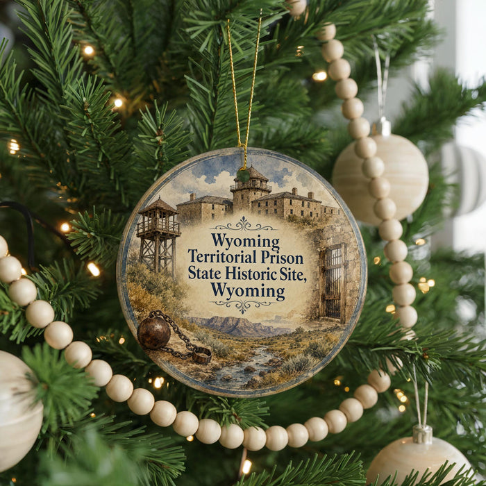 A circular ornament hanging on a Christmas tree, featuring an illustration of a historic prison and the text "Wyoming Territorial Prison State Historic Site Wyoming".