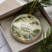A decorative ornament in a box, featuring a scenic image of York River State Park, Virginia.