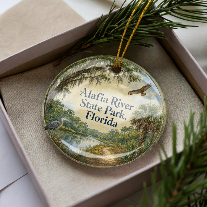 A decorative ornament in a box, featuring a scenic image of the Alafia River State Park in Florida.