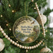 A circular ornament hanging on a Christmas tree, featuring a scenic image of the Alafia River State Park in Florida.