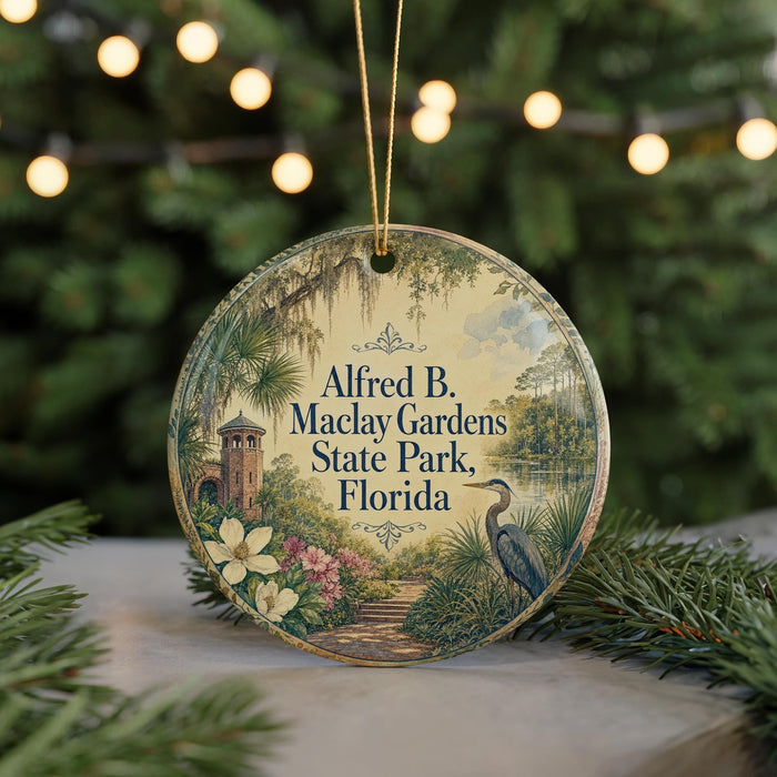 A round ornament with a floral design and text, hanging on a string, with a blurred background of greenery and lights.