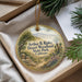 A decorative ornament with a landscape scene featuring mountains, trees, and a bird, placed in a box with pine branches.