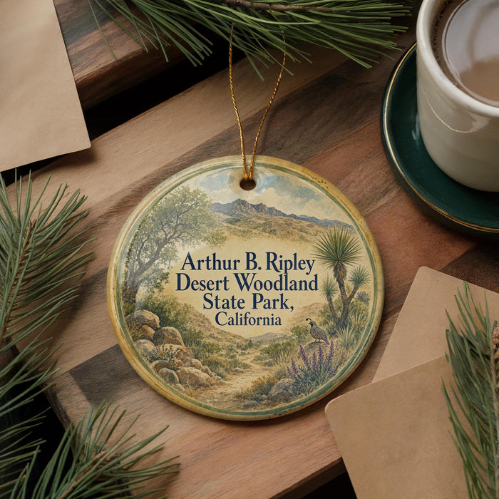 A decorative ornament with a landscape scene featuring mountains, trees, and a winding path, hanging on a wooden surface.