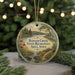 A circular ornament with a scenic landscape of Badger Creek State Recreation Area, Iowa, featuring a river, trees, and a bridge.
