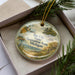 A round ornament with a scenic landscape of Bay City State Recreation Area, Michigan, featuring a lighthouse, pine trees, and a beach.