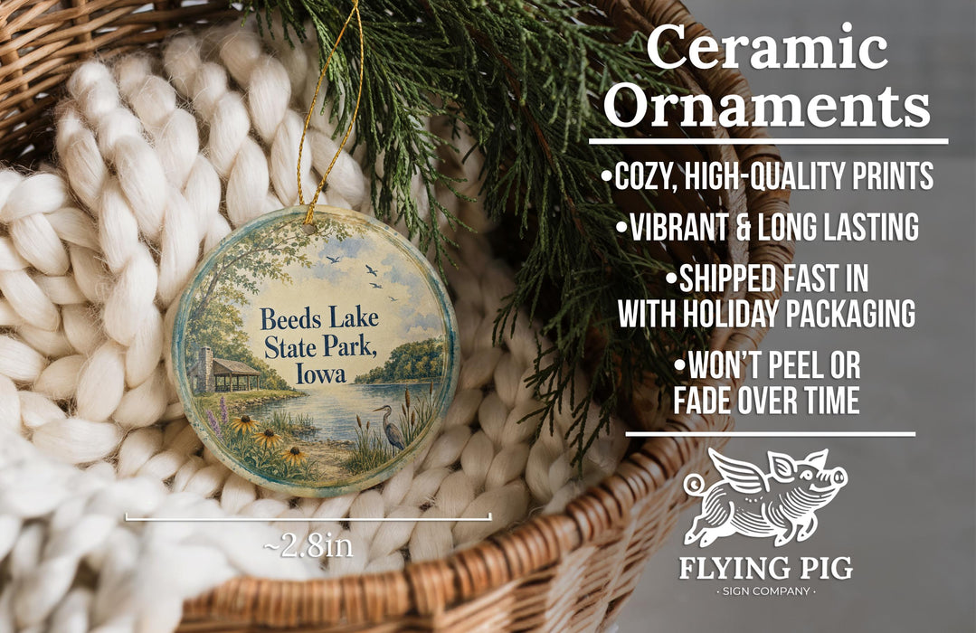 Ceramic ornaments, including a round ornament with a scenic view of Beeds Lake State Park, Iowa, hanging from a wicker basket.
