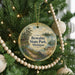 A round ornament hanging on a Christmas tree, featuring a scenic image of Bewabic State Park, Michigan.