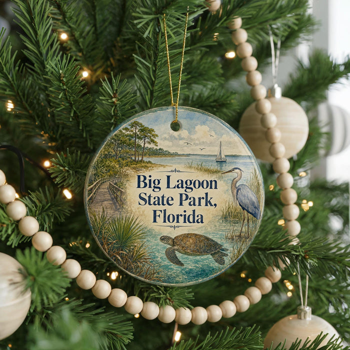 A round ornament hanging on a Christmas tree, featuring an illustration of a beach scene with a bird, palm tree, and a turtle.