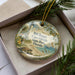 A decorative ornament featuring a lighthouse and beach scene, with the text "Bill Baggs Cape Florida State Park, Florida" printed on it.