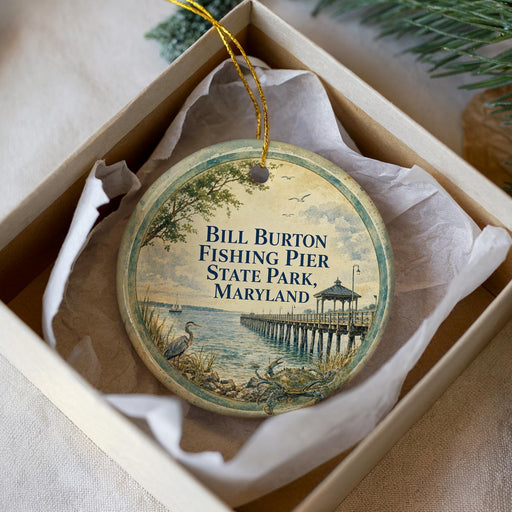 A round ornament in a box, featuring a scenic image of the Bill Burton Fishing Pier in Maryland.