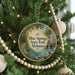 A round ornament hanging on a Christmas tree, featuring a scenic image of Blue Springs State Park in Alabama.