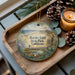 A decorative ornament with a scenic landscape of Border Field State Park, California, featuring a bird, pine cones, and a candle on a wooden tray.