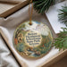 A decorative ornament with a landscape scene featuring a castle, mountains, and desert plants, hanging from a string.