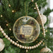 A round ornament hanging on a Christmas tree, featuring a scenic image of Brierfield Ironworks Historical State Park, Alabama.