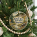 A round ornament hanging on a Christmas tree, featuring a scenic image of the buffalo river and buffalo in the background.