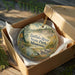 A decorative ornament in a box, featuring a scenic landscape of the Buffalo River State Park in Minnesota.