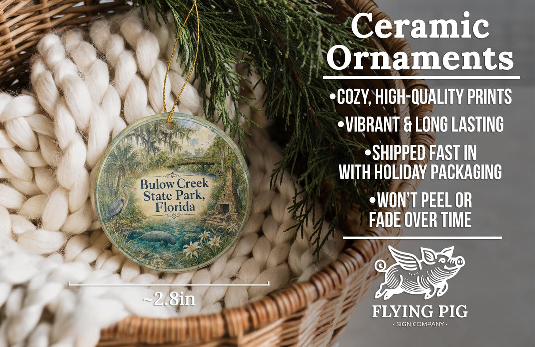 Ceramic ornaments, featuring a round ornament with a tropical forest scene, hanging from a wicker basket.