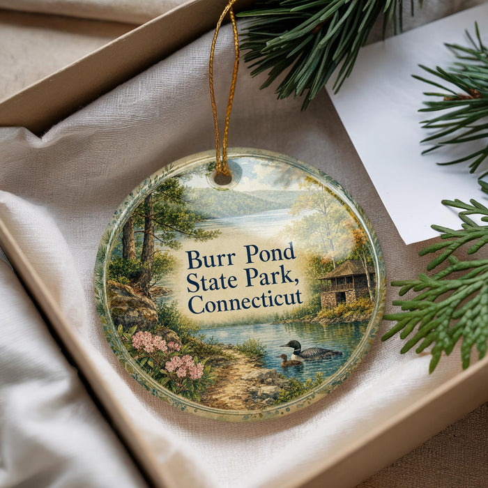 A decorative ornament with a scenic landscape of Burr Pond State Park, Connecticut, featuring a lake, trees, and a duck.