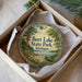 A round ornament with a scenic image of a lake and trees, featuring the text "Burst Lake State Park, Michigan".